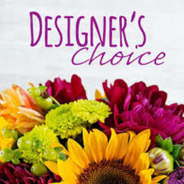 Bright mixed bouquet with sunflower and green mums under the words “Designer’s Choice” in purple text.