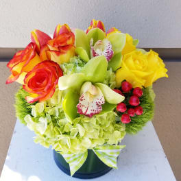 Bouquet of yellow and red roses with green orchids in a vase