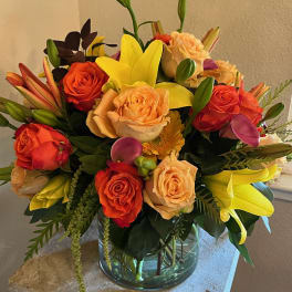 Mixed bouquet of roses and lilies in a glass vase