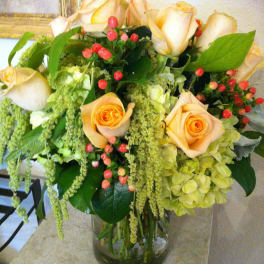 Peach roses and green hydrangeas in a glass vase