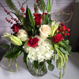 Bouquet of red and white roses with lilies and hydrangea in a glass vase