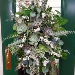 Tall green and white floral arrangement with succulents and eucalyptus