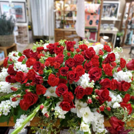 Large arrangement of red roses and white flowers on a table