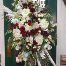Large standing floral spray with white, blush, and burgundy blooms