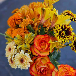 Bouquet of orange and yellow roses with mixed daisies and alstroemeria