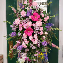 Tall pink and purple floral standing arrangement on a frame