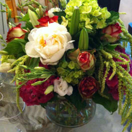 Mixed bouquet of roses, lilies, and hydrangeas in a glass vase
