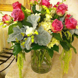 Pink roses and white flowers arranged in a clear glass vase