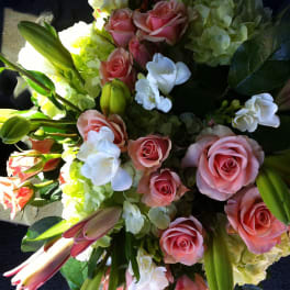 Bouquet of pink roses, white orchids, and pale green hydrangeas