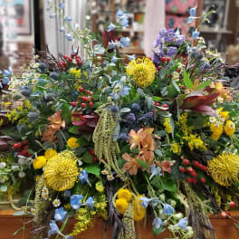 Large mixed floral arrangement with yellow, blue, and red blooms