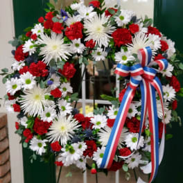Red, white, and blue floral wreath with a ribbon bow
