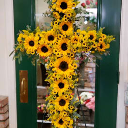 Yellow sunflower cross arrangement on a stand