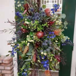 Large mixed floral arrangement with blue, red, and white blooms