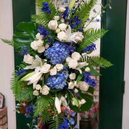 Tall blue and white floral arrangement with lilies, roses, and hydrangeas