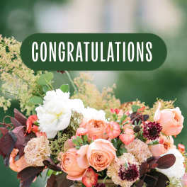 Peach and white rose bouquet with dark foliage and a congratulations sign