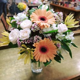 Bouquet of peach gerbera daisies and white roses in a clear glass vase