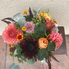Mixed bouquet with pink and peach blooms in a compact arrangement