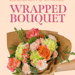 Wrapped bouquet of pink, peach, and green flowers in brown paper