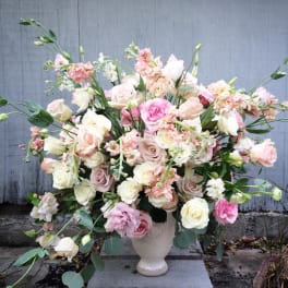 Large pastel bouquet of roses and lisianthus in a white vase