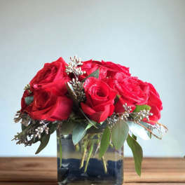 Red roses arranged in a square glass vase