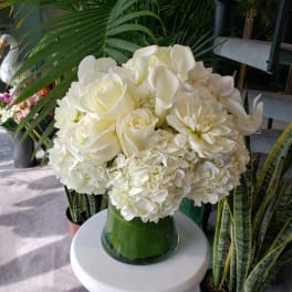 White roses and hydrangeas arranged in a glass vase