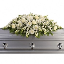 White floral casket spray on a gray casket