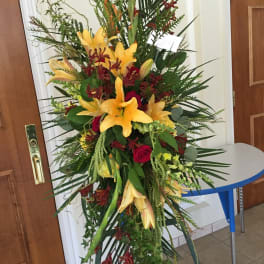 Tall floral spray with yellow lilies and red roses
