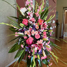 Tall pink and white floral standing arrangement with lilies and roses