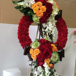 Large floral standing wreath with red, orange, and white flowers