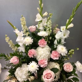 Pink roses, white hydrangeas, and white daisies in a tall arrangement