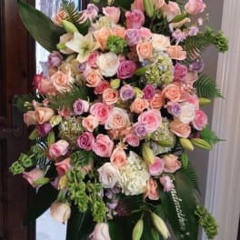 Large pastel rose and lily standing spray on an easel