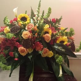 Large mixed floral spray with sunflowers, roses, and lilies in warm colors