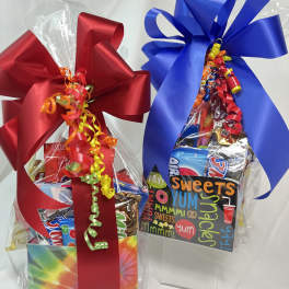 Two gift baskets of assorted candy wrapped with large red and blue bows