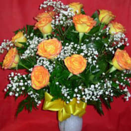 Yellow-orange roses with baby's breath in a white vase
