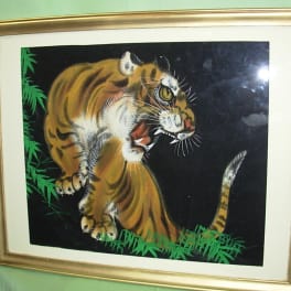 Framed painting of a tiger on a black background