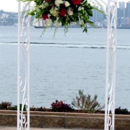 Floral arrangement on a white arch by the water