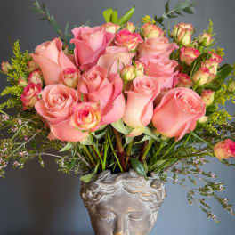 Pink roses arranged in a sculpted head vase