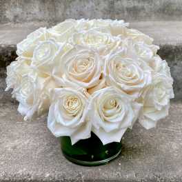 Round bouquet of white roses in a green glass vase