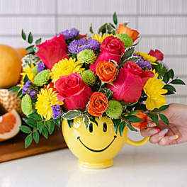 Colorful mixed bouquet in a yellow smiley-face mug