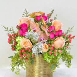 Pink and peach roses arranged in a gold vase