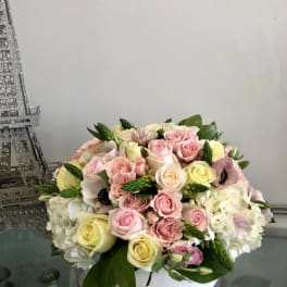 Bouquet of pink and cream roses with white hydrangeas in a white vase