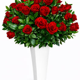 Bouquet of red roses in a tall white vase