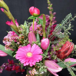 Pink mixed flower arrangement in a clear glass vase