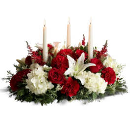 Red and white floral centerpiece with three lit taper candles