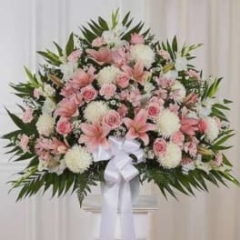 Large pink and white floral spray with a white ribbon bow