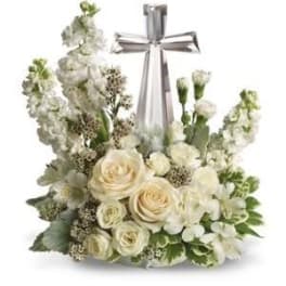 White floral arrangement with a silver cross centerpiece