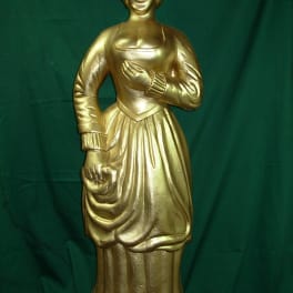 Gold-painted female statue against a green backdrop
