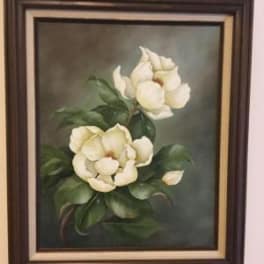 Framed painting of two white flowers with green leaves