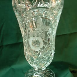 Ornate clear glass vase with a flared rim and pedestal base