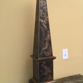 Tall decorative obelisk with floral pattern on a dark base